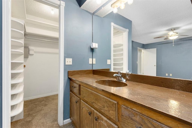 bathroom featuring ceiling fan, a textured ceiling, and vanity