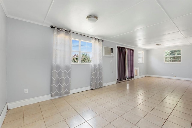 tiled empty room featuring a wall unit AC and crown molding