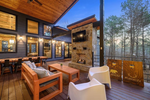 wooden deck with an outdoor living space with a fireplace