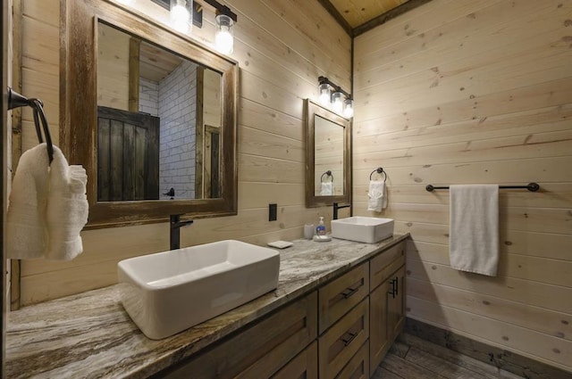 bathroom featuring hardwood / wood-style floors, vanity, and wooden walls