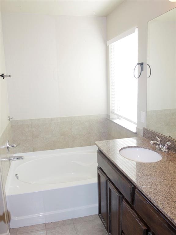 bathroom featuring tile patterned floors, vanity, and a tub to relax in