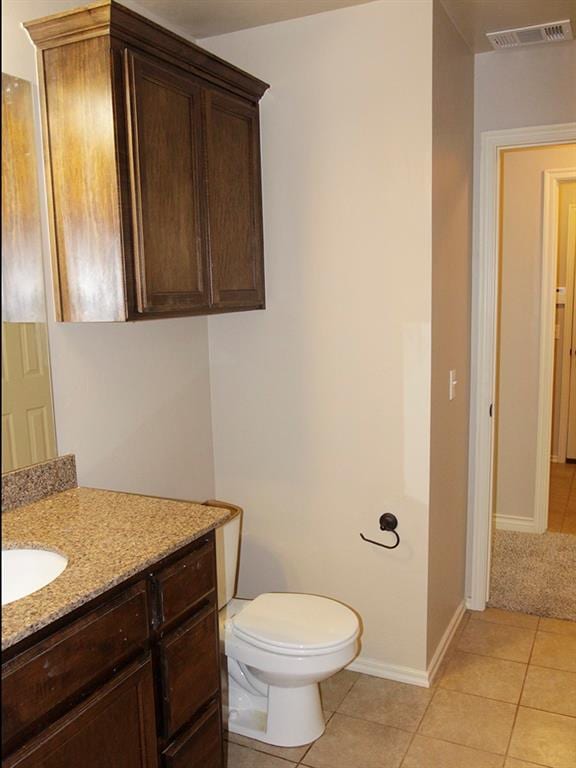 bathroom with tile patterned flooring, vanity, and toilet