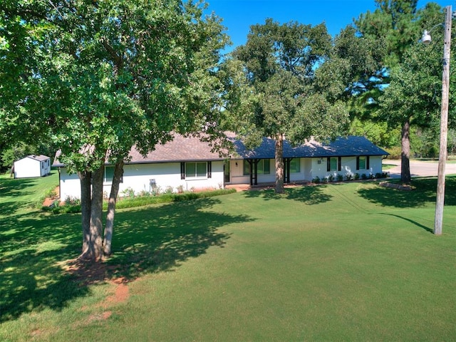 ranch-style house with a front yard and a shed