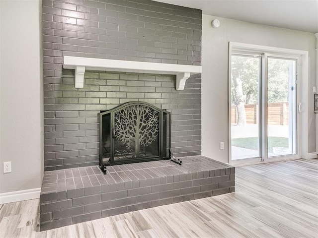 interior details featuring a brick fireplace and hardwood / wood-style flooring