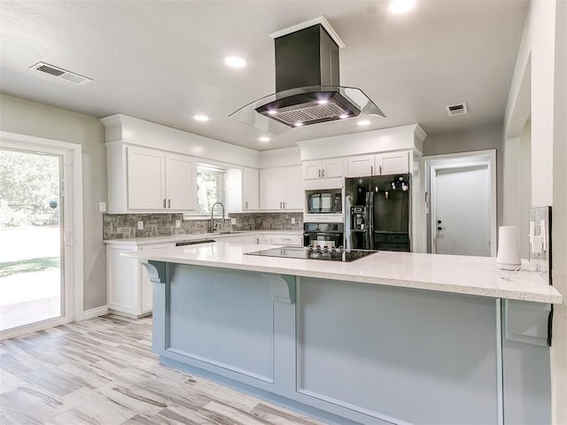 kitchen with white cabinets, island range hood, kitchen peninsula, and black appliances