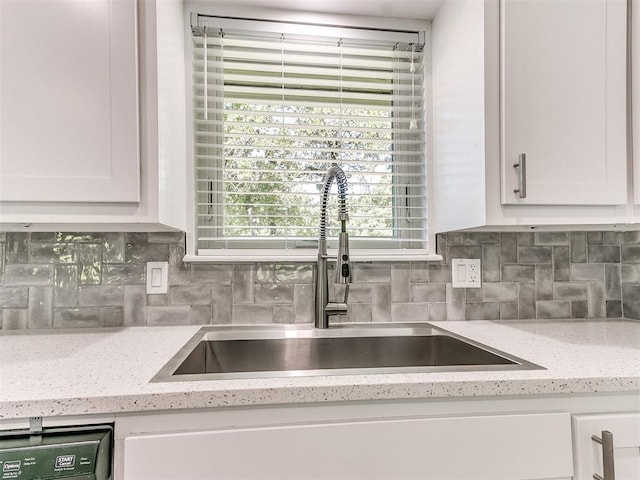 kitchen with sink, dishwashing machine, light stone counters, decorative backsplash, and white cabinets