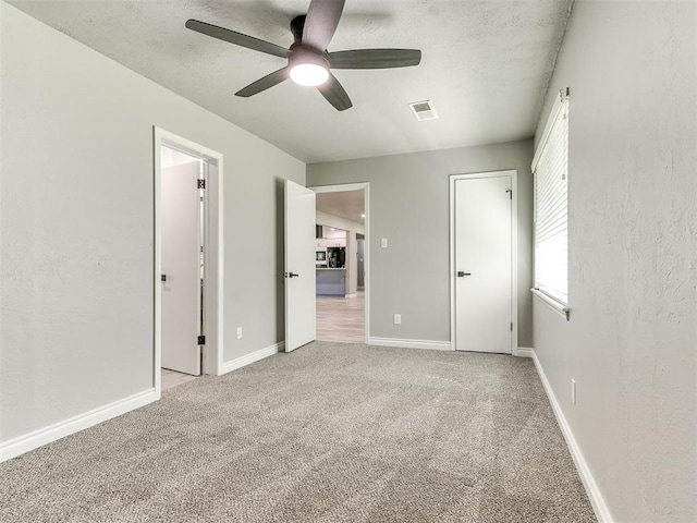 unfurnished bedroom with ceiling fan and light carpet