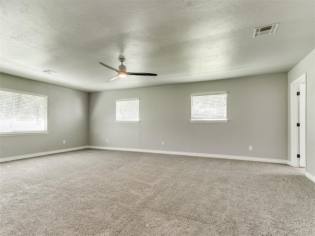 spare room with carpet, a textured ceiling, and ceiling fan