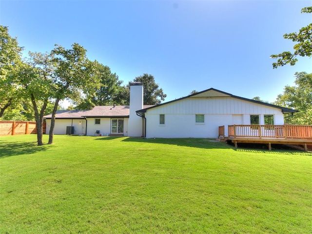 back of property with a yard and a wooden deck