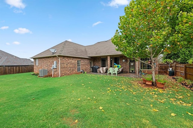 back of property featuring central AC unit and a lawn