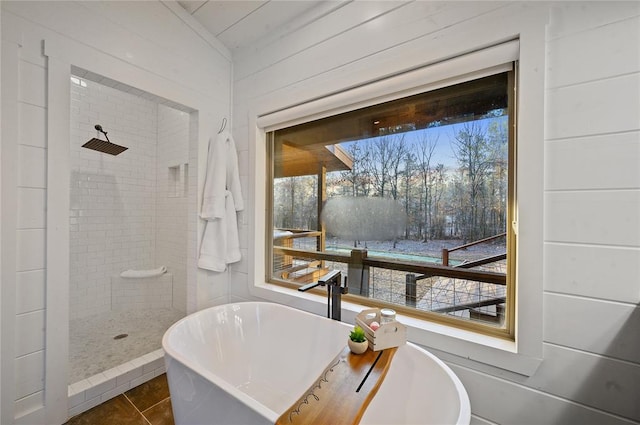 bathroom with tile patterned floors, separate shower and tub, and wooden walls