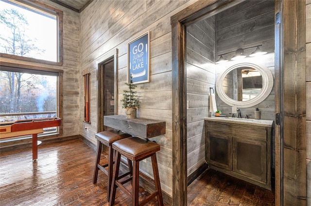 interior space featuring wooden walls, sink, and dark hardwood / wood-style floors