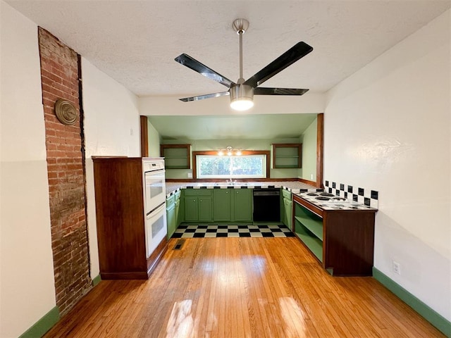 kitchen featuring dishwasher, sink, light hardwood / wood-style flooring, green cabinetry, and ceiling fan