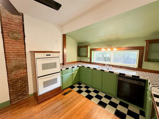 kitchen with sink, dishwasher, double oven, light hardwood / wood-style floors, and green cabinetry