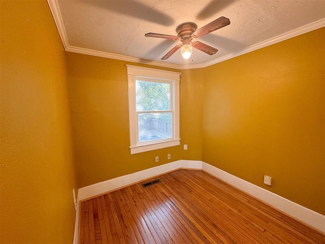 empty room with ceiling fan, wood-type flooring, and ornamental molding