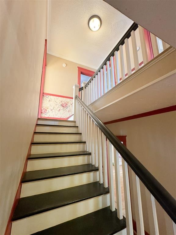 stairway with a textured ceiling