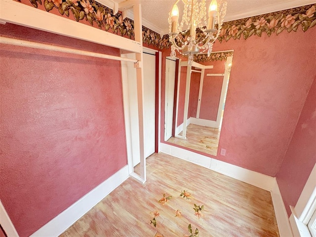 spacious closet with hardwood / wood-style floors and a notable chandelier