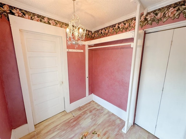 bathroom featuring a notable chandelier, crown molding, a textured ceiling, and hardwood / wood-style flooring