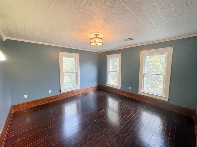 empty room featuring a wealth of natural light, crown molding, and wood-type flooring