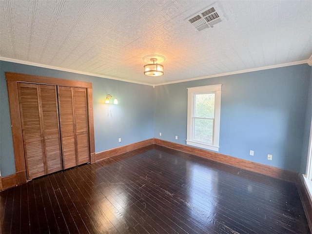 unfurnished bedroom featuring crown molding, a closet, dark wood-type flooring, and a textured ceiling