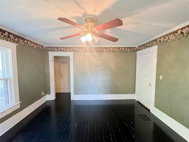 spare room with dark hardwood / wood-style floors, ceiling fan, ornamental molding, and a textured ceiling