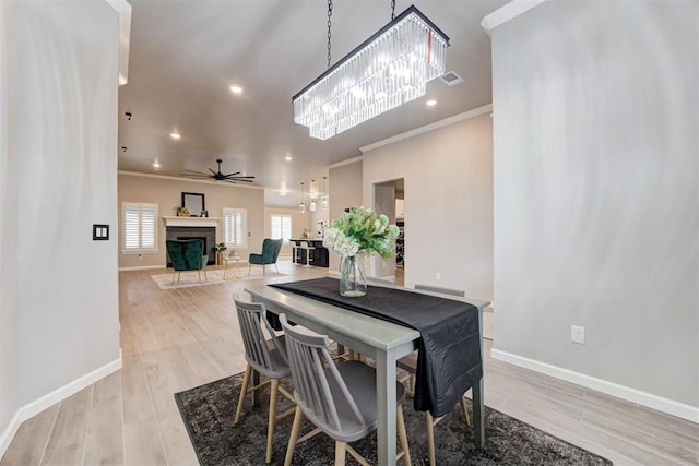 dining room featuring light hardwood / wood-style floors, ceiling fan, and crown molding