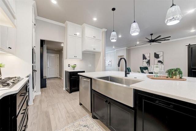 kitchen with white cabinets, decorative light fixtures, sink, and stainless steel appliances