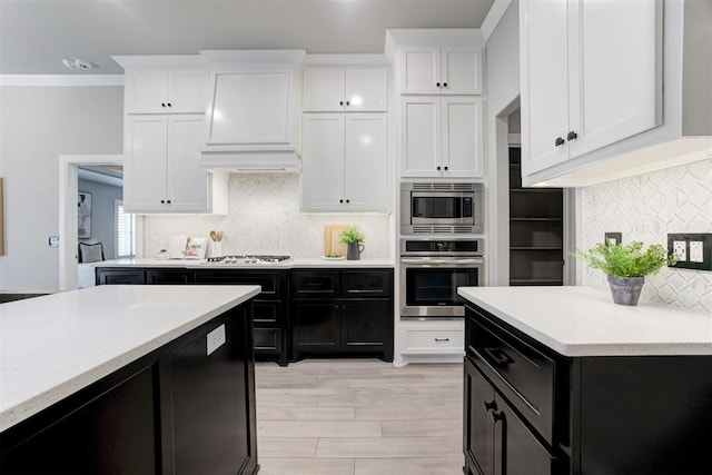 kitchen featuring white cabinets, stainless steel appliances, and tasteful backsplash