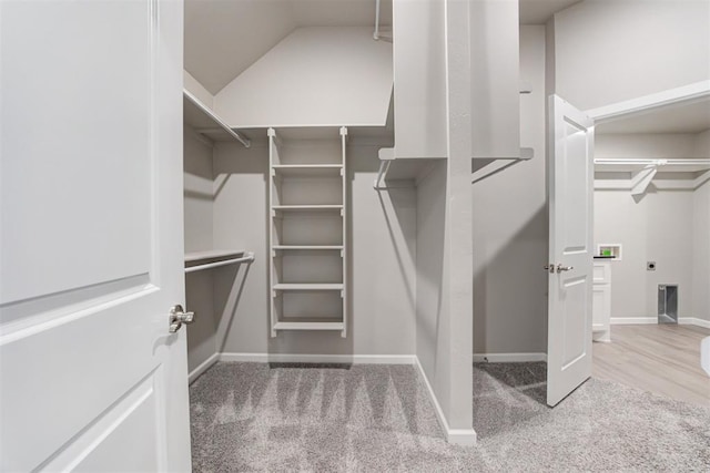 spacious closet with hardwood / wood-style floors and lofted ceiling