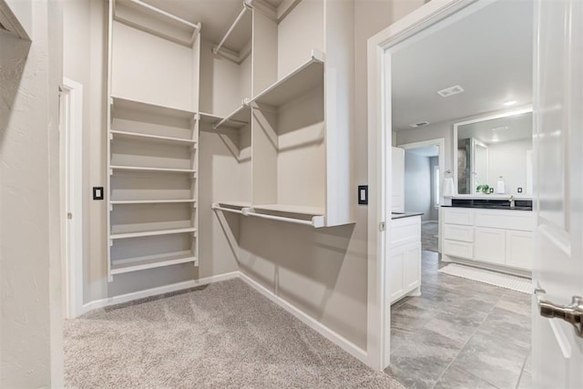 spacious closet with light carpet and sink