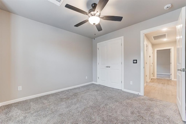 unfurnished bedroom with light colored carpet and ceiling fan