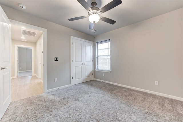 unfurnished bedroom featuring ceiling fan, a closet, and light carpet