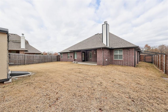 back of house with a patio area and a yard