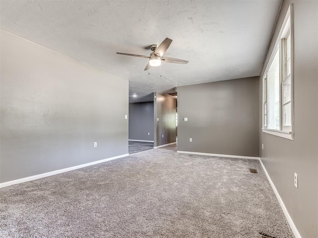 carpeted empty room featuring ceiling fan and a textured ceiling