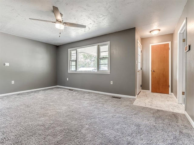 interior space with carpet flooring, ceiling fan, and a textured ceiling