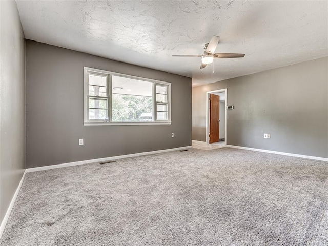 spare room featuring carpet flooring, ceiling fan, and a textured ceiling