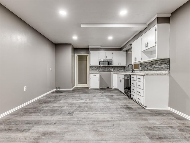 kitchen with sink, black dishwasher, light hardwood / wood-style flooring, decorative backsplash, and white cabinets