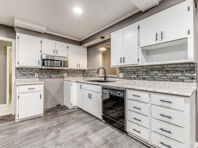 kitchen featuring light wood-type flooring, sink, decorative light fixtures, black dishwasher, and white cabinetry