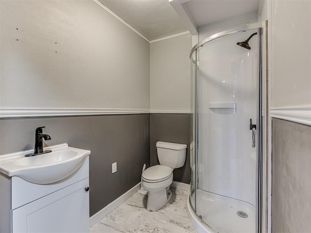 bathroom featuring vanity, toilet, a shower with shower door, and crown molding