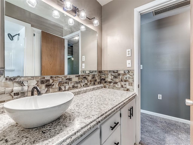 bathroom featuring vanity and tasteful backsplash