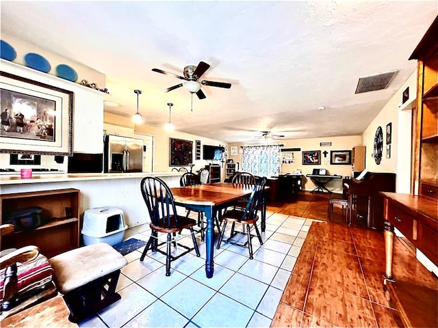 tiled dining space featuring ceiling fan