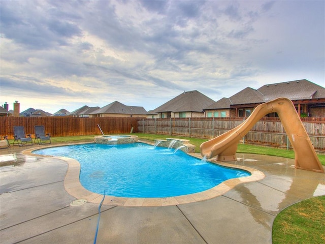 view of swimming pool featuring a patio area, an in ground hot tub, pool water feature, and a water slide