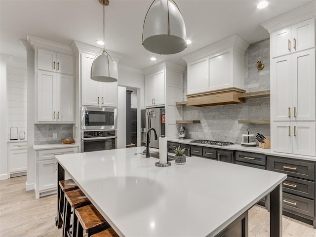 kitchen featuring white cabinetry, pendant lighting, tasteful backsplash, and stainless steel appliances