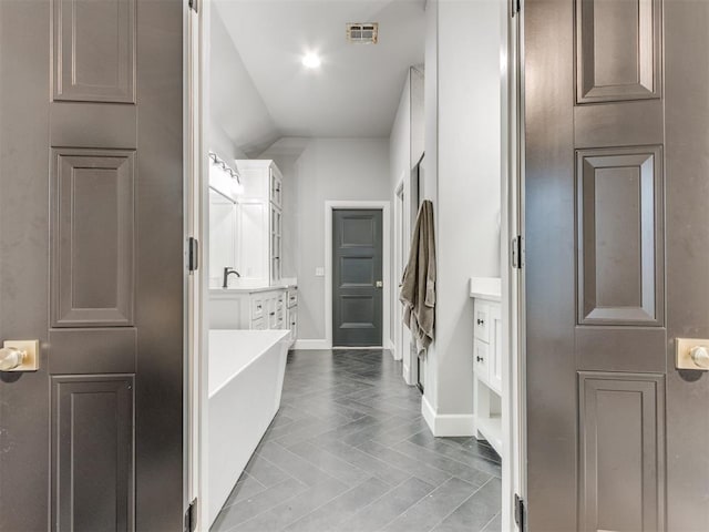 bathroom with vanity, tile patterned flooring, and a bathtub