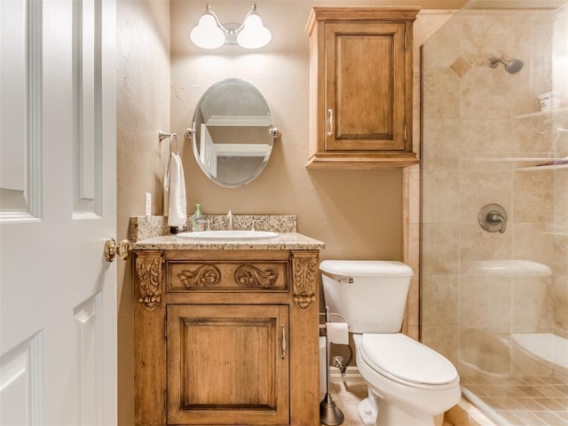 bathroom featuring tiled shower, vanity, and toilet