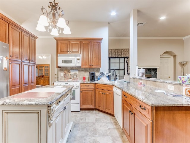 kitchen with a chandelier, white appliances, ornamental molding, and sink