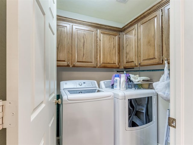 laundry area with washer and dryer and cabinets