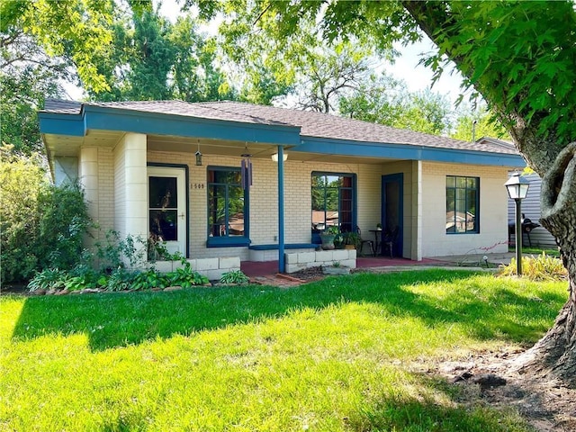 rear view of house featuring covered porch and a lawn