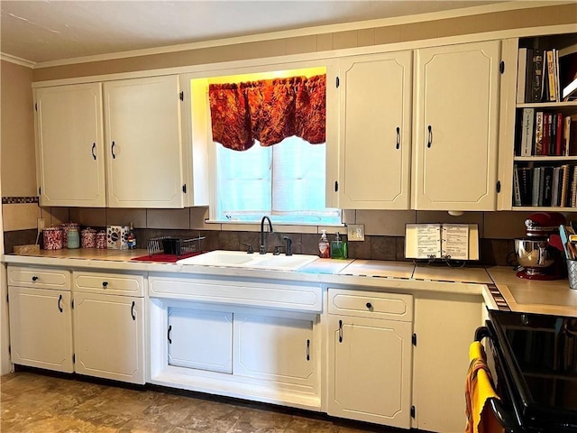 kitchen with ornamental molding, sink, white cabinets, and electric range