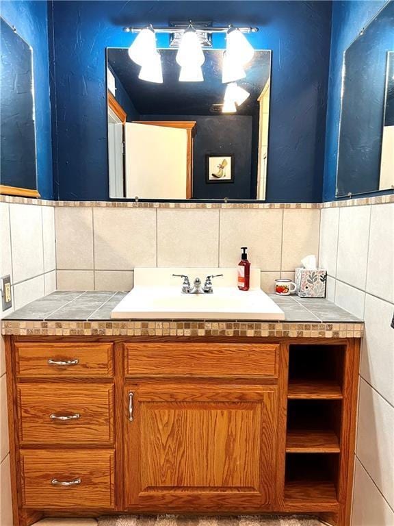 bathroom with vanity and tile walls